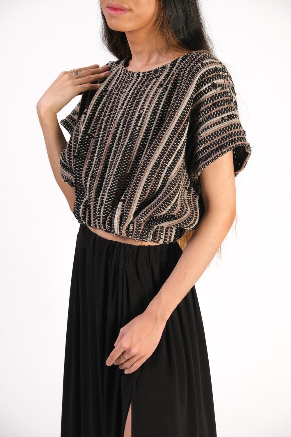 2/3 view of the handwoven srey cinched top in onyx showing slightly open sleeve and gathered waist; designed as part of tonlé's sustainable spring 2022 collection.