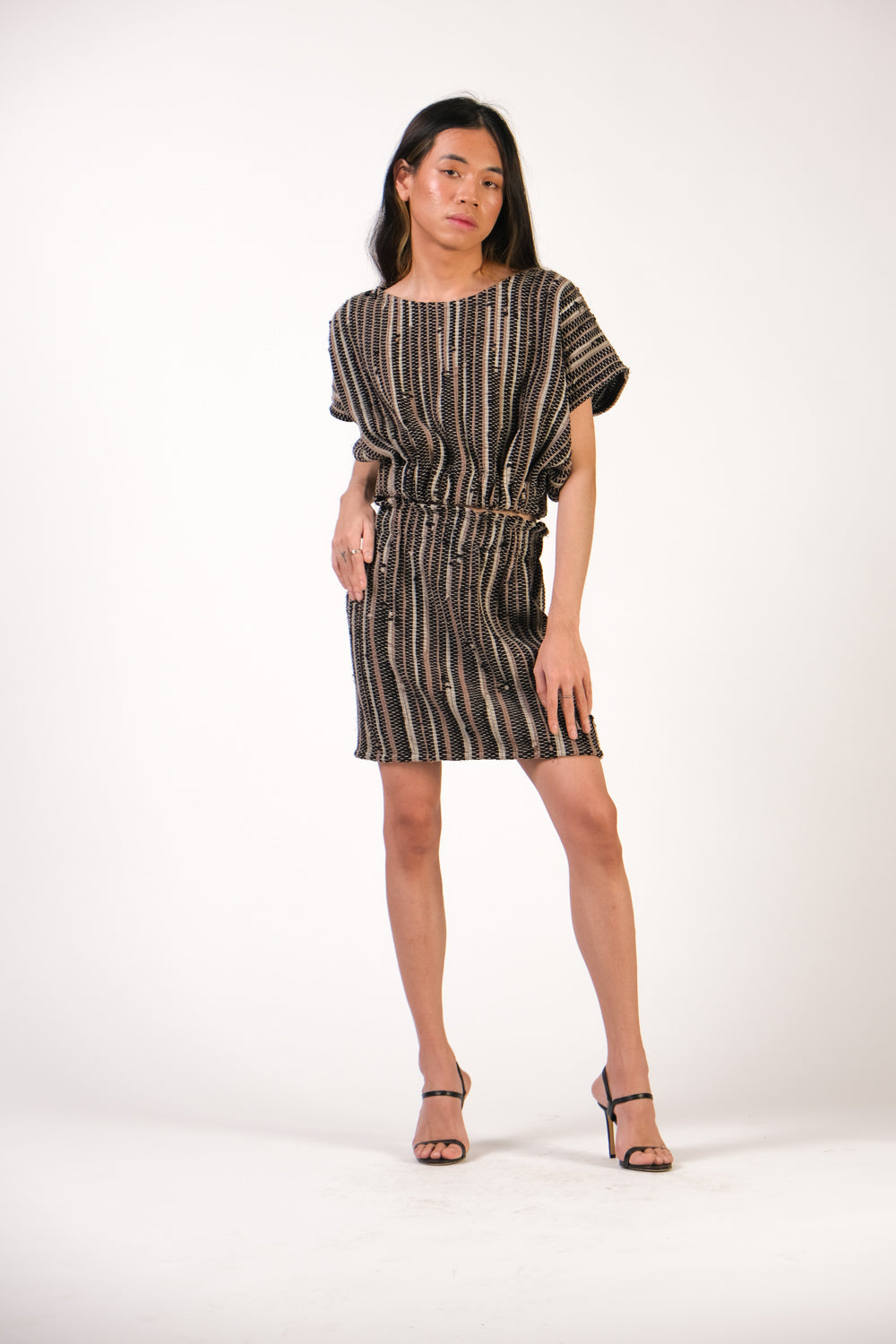 Front view of a full outfit from tonlé's sustainable fashion line for spring featuring the srey cinch top in onyx with matching srey mini skirt