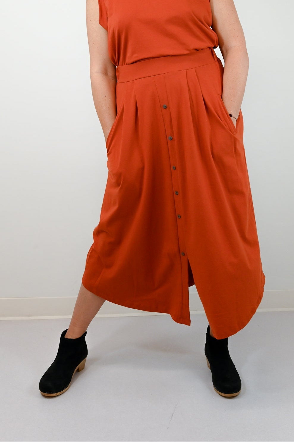 Woman wearing an orange dress with a white background