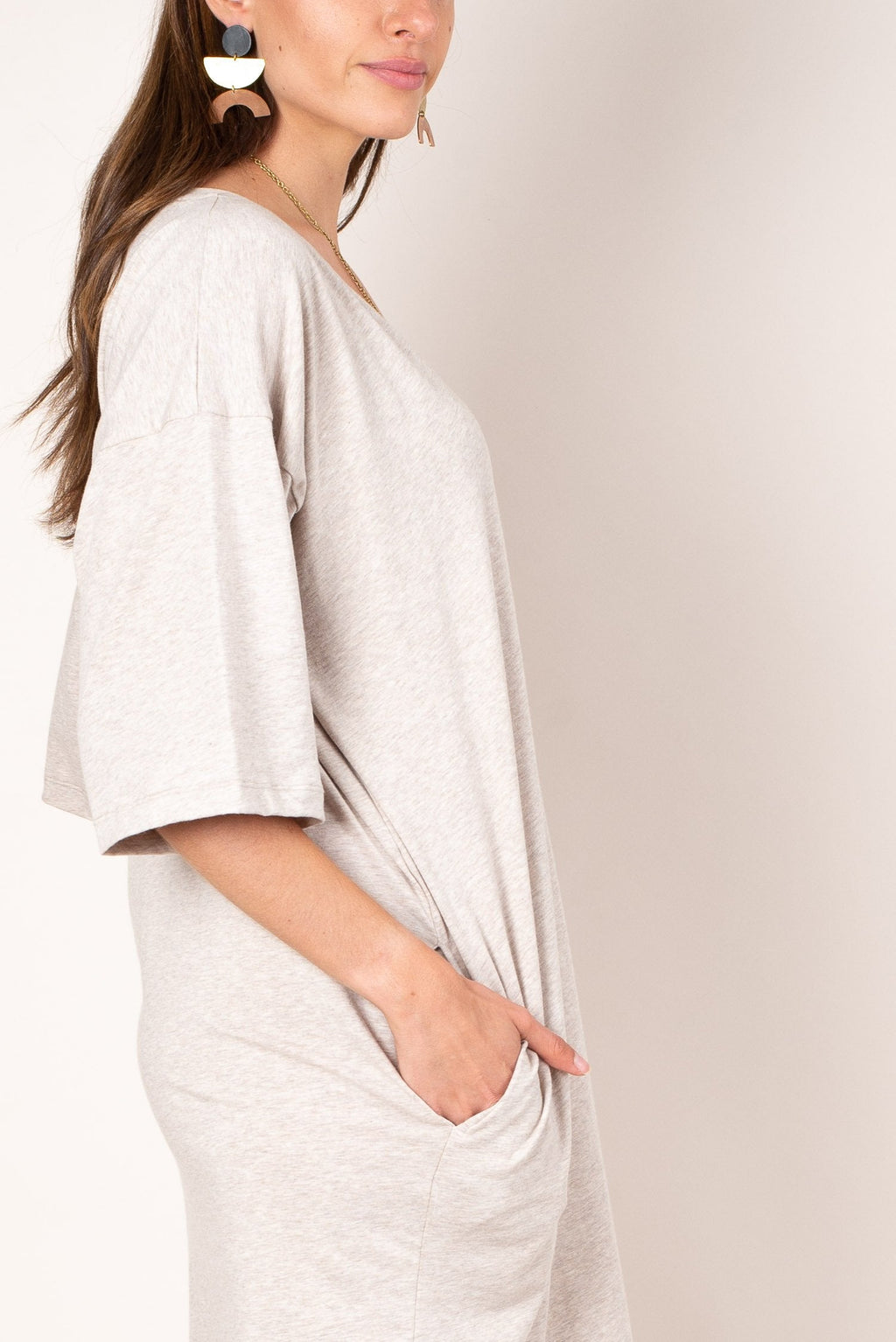 A close up view of the ultra soft and lightweight oatmeal colored reclaimed jersey of our v-neck t-shirt dress with deep side pockets.