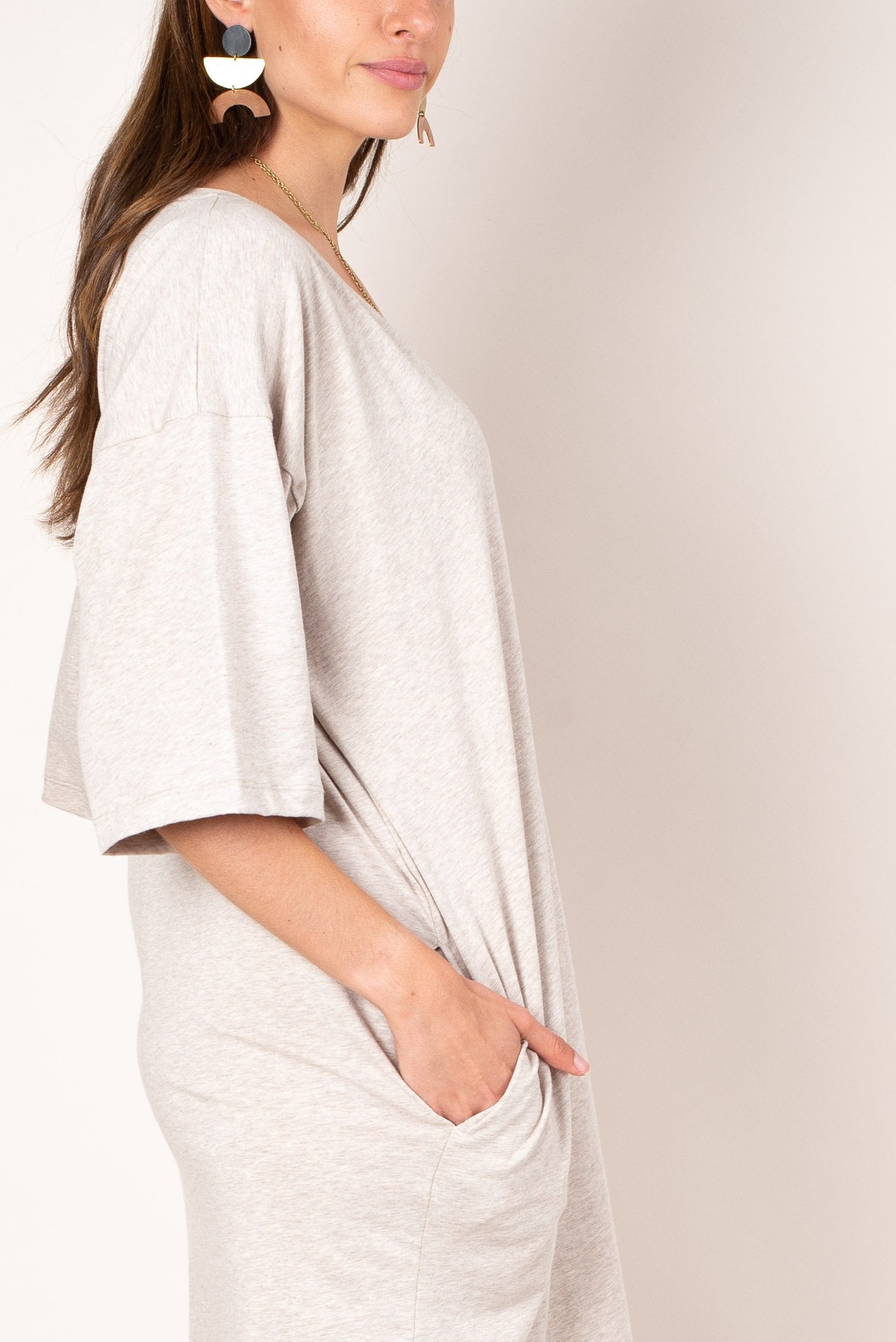 A close up view of the ultra soft and lightweight oatmeal colored reclaimed jersey of our v-neck t-shirt dress with deep side pockets.